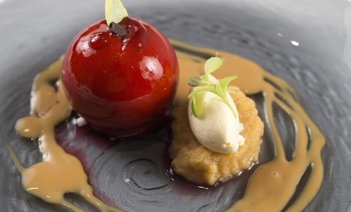 A beautifully plated chef's dessert featuring elegant presentation and decorative garnishes, served as part of a premium event dining experience.